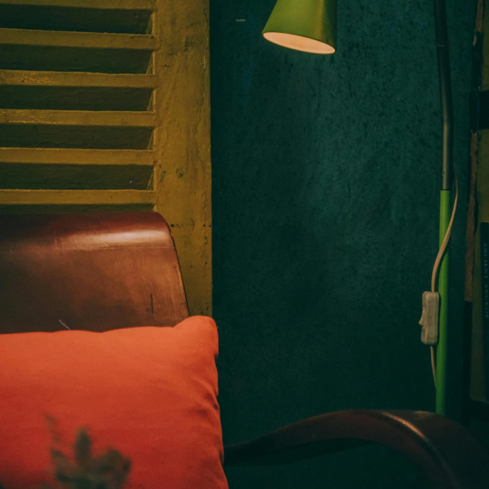 A warm, softly lit sitting space — armchair, lamp, and natural light